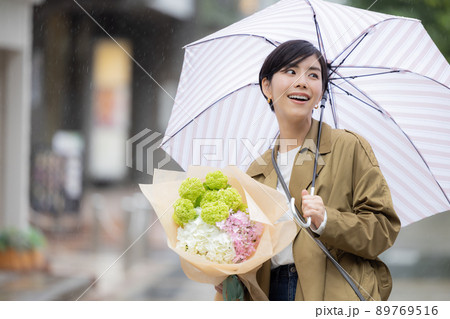 雨の日 紫陽花を持って歩く女性 雨の日 紫陽花を持って歩く女性 89769516