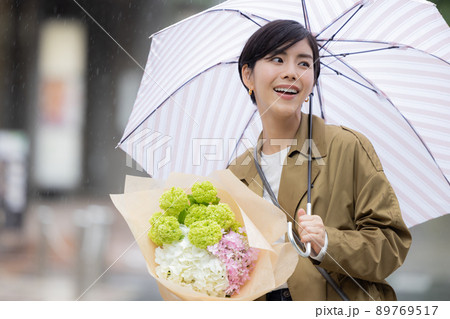 雨の日　紫陽花を持って歩く女性 89769517