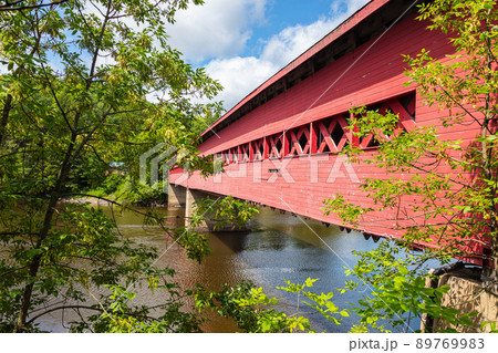 Wakefield, Quebec, Canada - August 30, 2021: Wakefield Covered Bridge crossing the river Gatineau. Wooden bridge in the rural Quebec landscape. The riverbank invites you to swim in the cold water 89769983