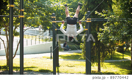An athletic man exercising on the horizontal bar 89770442