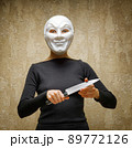 Woman in white mask holding the knife 89772126