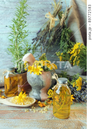 Useful plants, oils and tinctures, lavender flowers, calendula, tansy and rosemary, on a wooden background, natural ingredients, alternative medicine 89772583