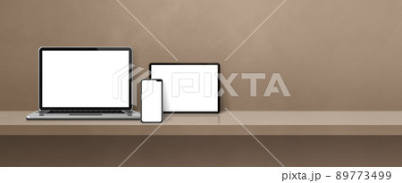 Laptop, mobile phone and digital tablet pc on brown wall shelf. Banner background 89773499
