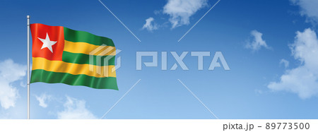 Togo flag isolated on a blue sky. Horizontal banner 89773500
