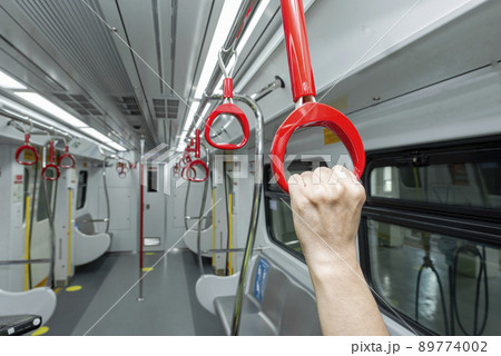 Passenger hand holding handle on the train Passenger hand holding handle on the train 89774002