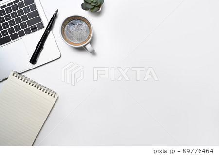 Minimal workplace with laptop computer, coffee cup, notepad and potted plant. Flat lay, Top view with copy space 89776464