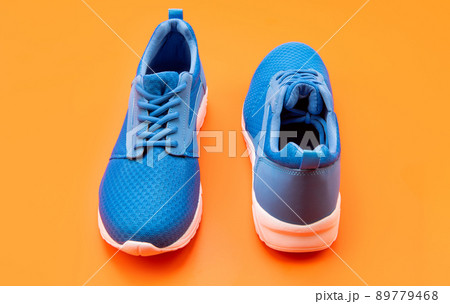 pair of comfortable blue sport shoes on orange background, fitness pair of comfortable blue sport shoes on orange background, fitness 89779468