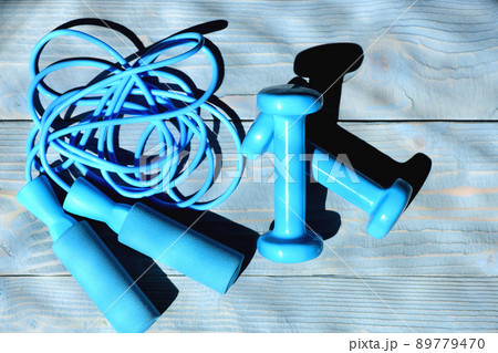 Barbells and messy skipping rope placed crosswise. Barbells and messy skipping rope placed crosswise. 89779470