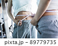 メジャーでウエストを測る若い女性 89779735