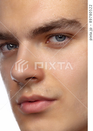 Closeup male blue eyes of young handsome man isolated on white studio background. Concept of men's health, vision, self-care, medicine and cosmetics. 89780522