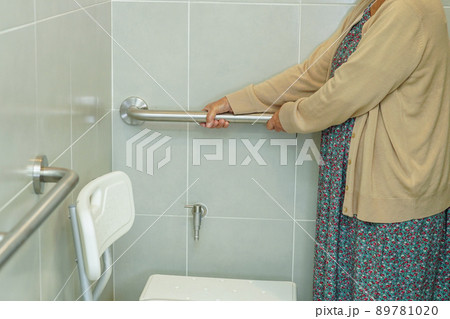 Asian elderly old woman patient use toilet support rail in bathroom, handrail safety grab bar, security in nursing hospital. Asian elderly old woman patient use toilet support rail in bathroom, handrail safety grab bar, security in nursing hospital. 89781020