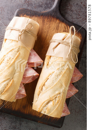 French sandwich crusty baguette, lightly salted butter and thinly sliced ham, ideally Jambon de Paris. Vertical top view French sandwich crusty baguette, lightly salted butter and thinly sliced ham, ideally Jambon de Paris. Vertical top view 89781578