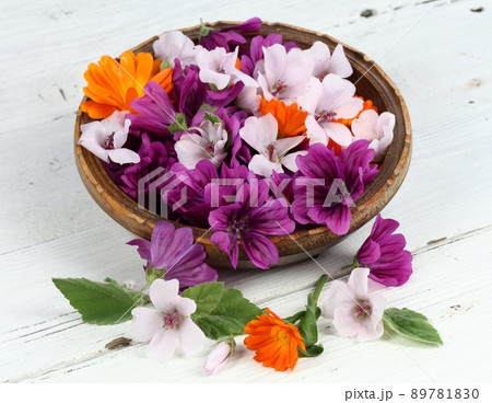 Beautiful flowers of medicinal herbs  in a bowl on the white wooden table 89781830