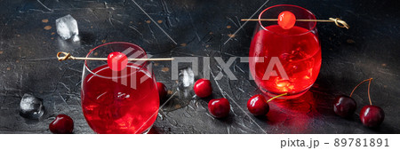 Cocktail with cherry and ice panorama, an aperitif with a garnish Cocktail with cherry and ice panorama, an aperitif with a garnish 89781891