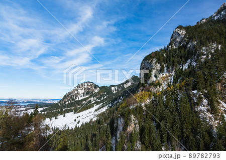 ドイツ　ノイシュヴァンシュタイン城の後ろに広がる雪化粧の山とペラート峡谷 89782793