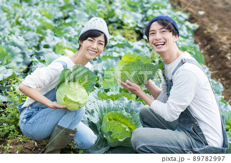 キャベツの収穫を楽しむ若い男女 89782997