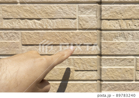 外壁のコーキングを点検する男性のイメージ 89783240