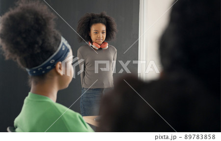 African American girl student introduces himself nonconfidently in class. African American girl student introduces himself nonconfidently in class. 89783858