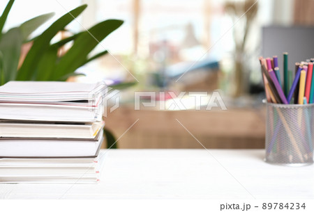 home workspace with books and color pencils on white table. copy space for product placement. learning at home or distant education. home workspace with books and color pencils on white table. copy space for product placement. learning at home or distant education. 89784234