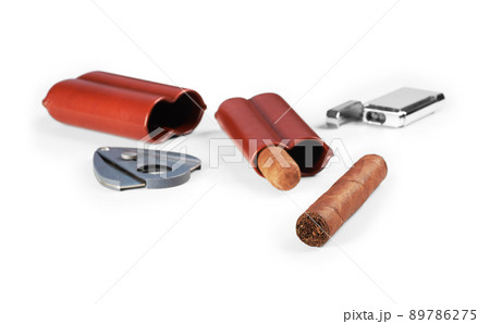 Two cuban cigars isolated on a white background. Leather case, lighter and cutter. Two cuban cigars isolated on a white background. Leather case, lighter and cutter. 89786275