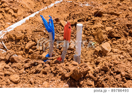 Laying water PVC plastic pipes in ground during plumbing construction site. Laying water PVC plastic pipes in ground during plumbing construction site. 89786493