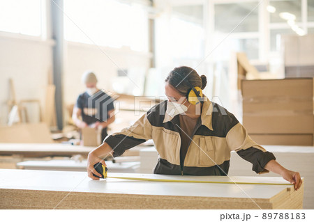 Female worker using tape measure at work 89788183