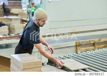 Carpenter working at machine with timber 89788327