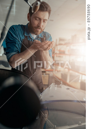 Male Barista in uniform inhaling the aroma of coffee in own manufacturing of roasted coffee beans 89788690