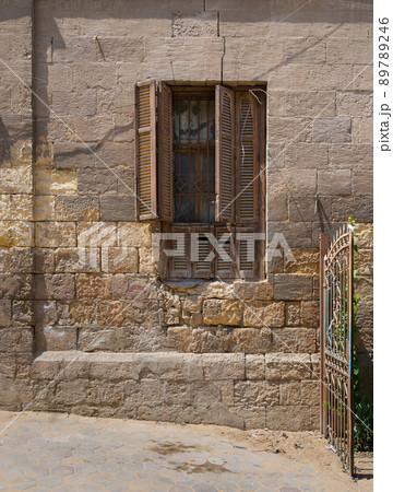 Broken windows and grunge stone bricks wall, Cairo, Egypt Broken windows and grunge stone bricks wall, Cairo, Egypt 89789246