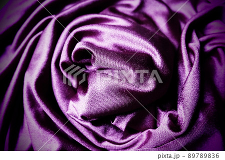 Velour fabric, similar to silk. Textiles in a folds, beautiful waves, twisted into a circle. Purple, pink, magenta shades on the drapery. Sewing material for dresses, furniture upholstery, curtains 89789836