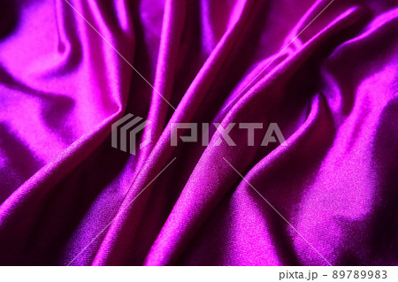 Velour fabric, similar to silk. Textiles in a folds and beautiful waves. Purple, pink, magenta shades on the drapery. Sewing material for evening dresses, furniture upholstery, curtains and interior 89789983