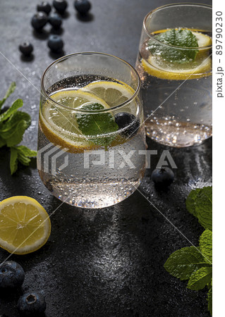 Detox water, infused refreshing drink with lemon and blueberry and mint. Dark moody photo Detox water, infused refreshing drink with lemon and blueberry and mint. Dark moody photo 89790230