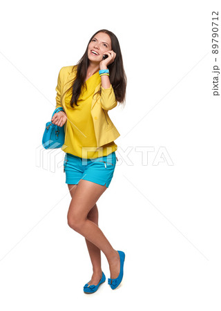 Young woman in full length talking on cellphone, over white background 89790712