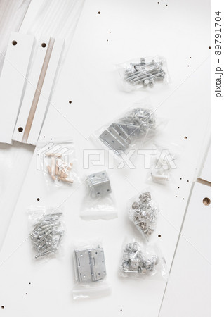 Box with furniture assembly parts on the floor 89791704