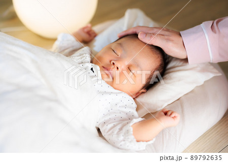 夜 寝かし付け 頭を撫でるママと眠る赤ちゃん 夜 寝かし付け 頭を撫でるママと眠る赤ちゃん 89792635