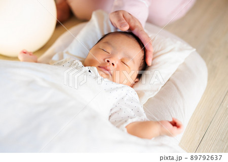 夜 寝かし付け 頭を撫でるママと眠る赤ちゃん 夜 寝かし付け 頭を撫でるママと眠る赤ちゃん 89792637