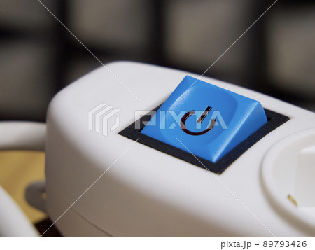 Blue power button on white extension cable. Power button, close-up shot. 89793426