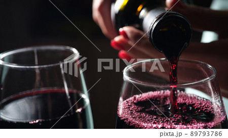 Woman pouring red wine into glass, tasting and degustation Woman pouring red wine into glass, tasting and degustation 89793786