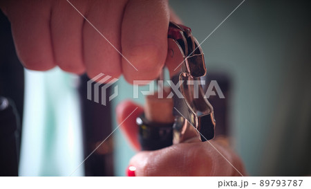 Woman opening bottle of wine with corkscrew Woman opening bottle of wine with corkscrew 89793787