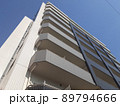 青空の下、そびえ立つ高層マンション 89794666