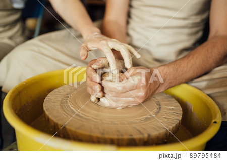 Hands of a potter. Potter making ceramic pot on the pottery wheel 89795484