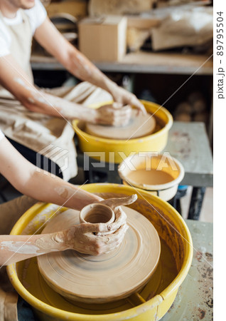 Hands of a potter. Potter making ceramic pot on the pottery wheel 89795504
