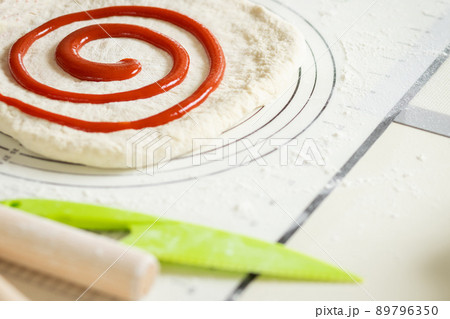 Berry jam spirally applied to rolled out dough for a sweet dessert roll 89796350