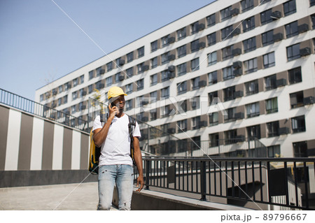 African courier looks at his smartphone, checking his destination. 89796667
