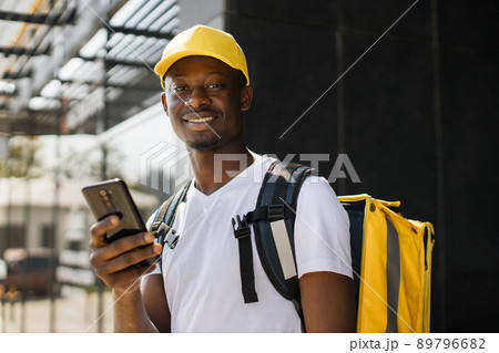 Courier man with mobile phone looking for deliver address of food from a restaurant. 89796682