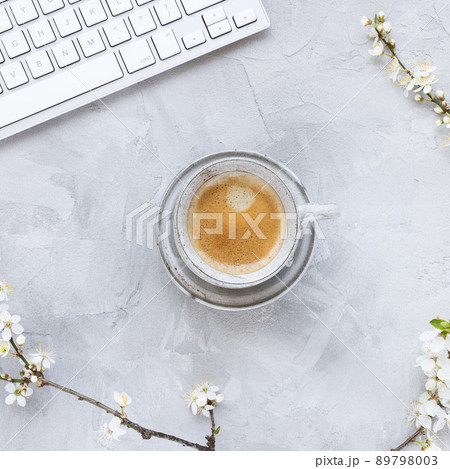 Computer keyboard on spring background with white blooming tree branches and morning espresso coffee Computer keyboard on spring background with white blooming tree branches and morning espresso coffee 89798003