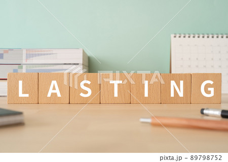 永続・長続きのイメージ｜「LASTING」と書かれた積み木が置かれたデスク 89798752