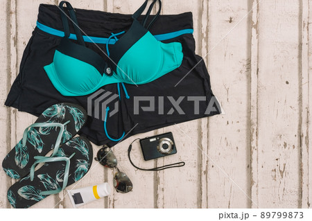 top view beach objects. swimming costume, flip-flops, sunglasses and compact camera for holidays. top view beach objects. swimming costume, flip-flops, sunglasses and compact camera for holidays. 89799873