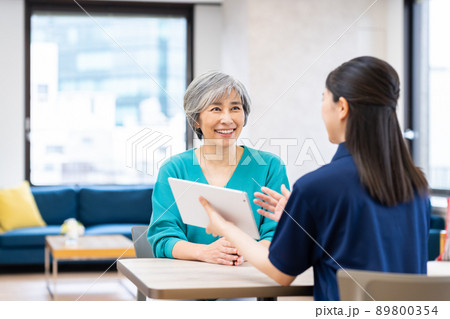ケアマネージャーに介護の相談をするミドルの女性 ケアマネージャーに介護の相談をするミドルの女性 89800354