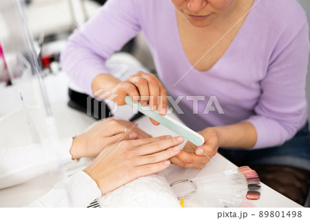 Closeup of female hands during professional manicure in beauty parlor 89801498